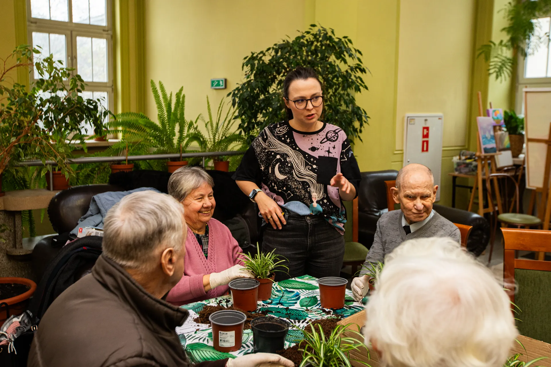 Wolontariuszka fundacji prowadzi zajęcia z roślinami dla seniorów