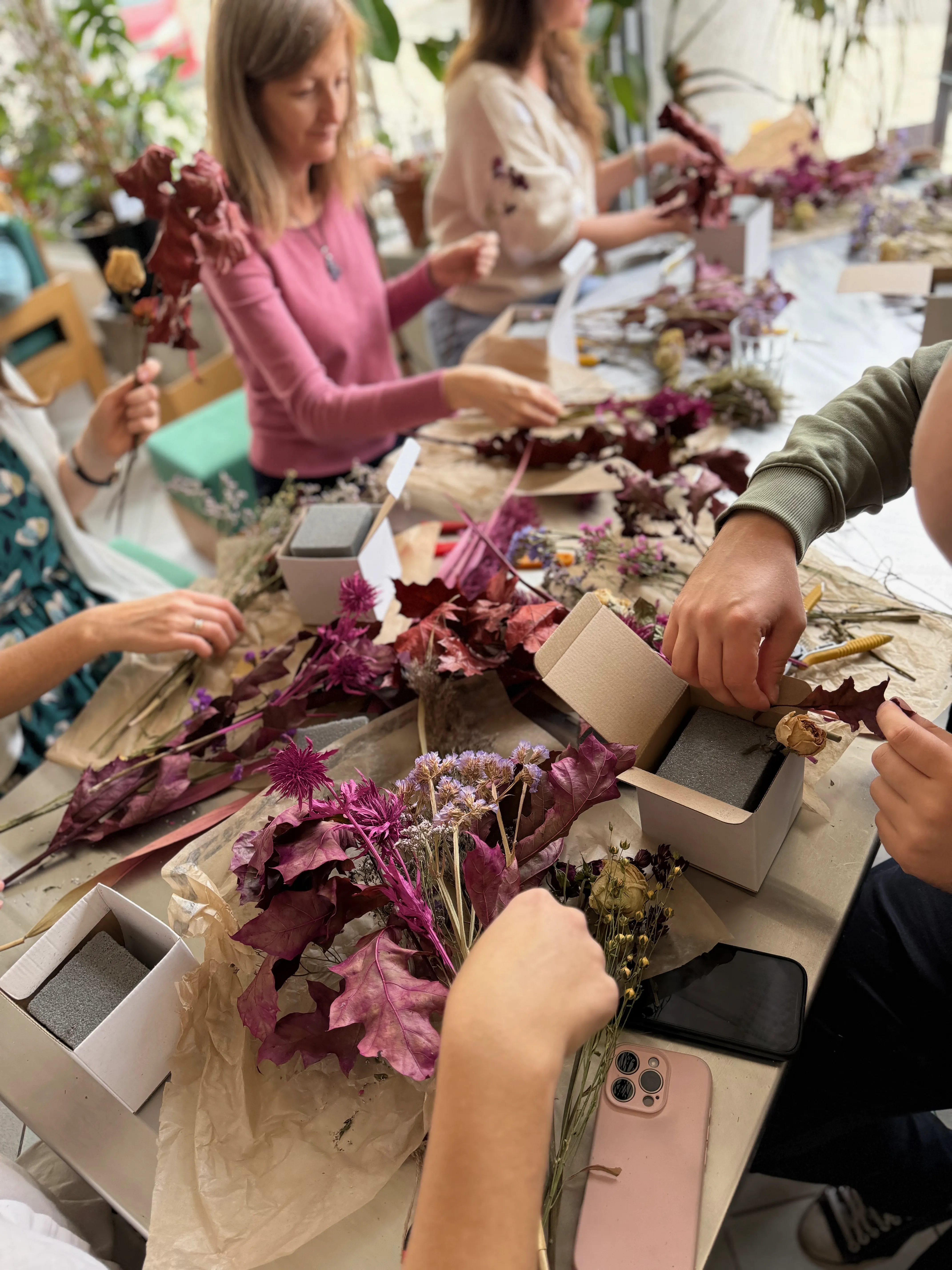 Komponowanie flowerboxów przy stole w kawiarni