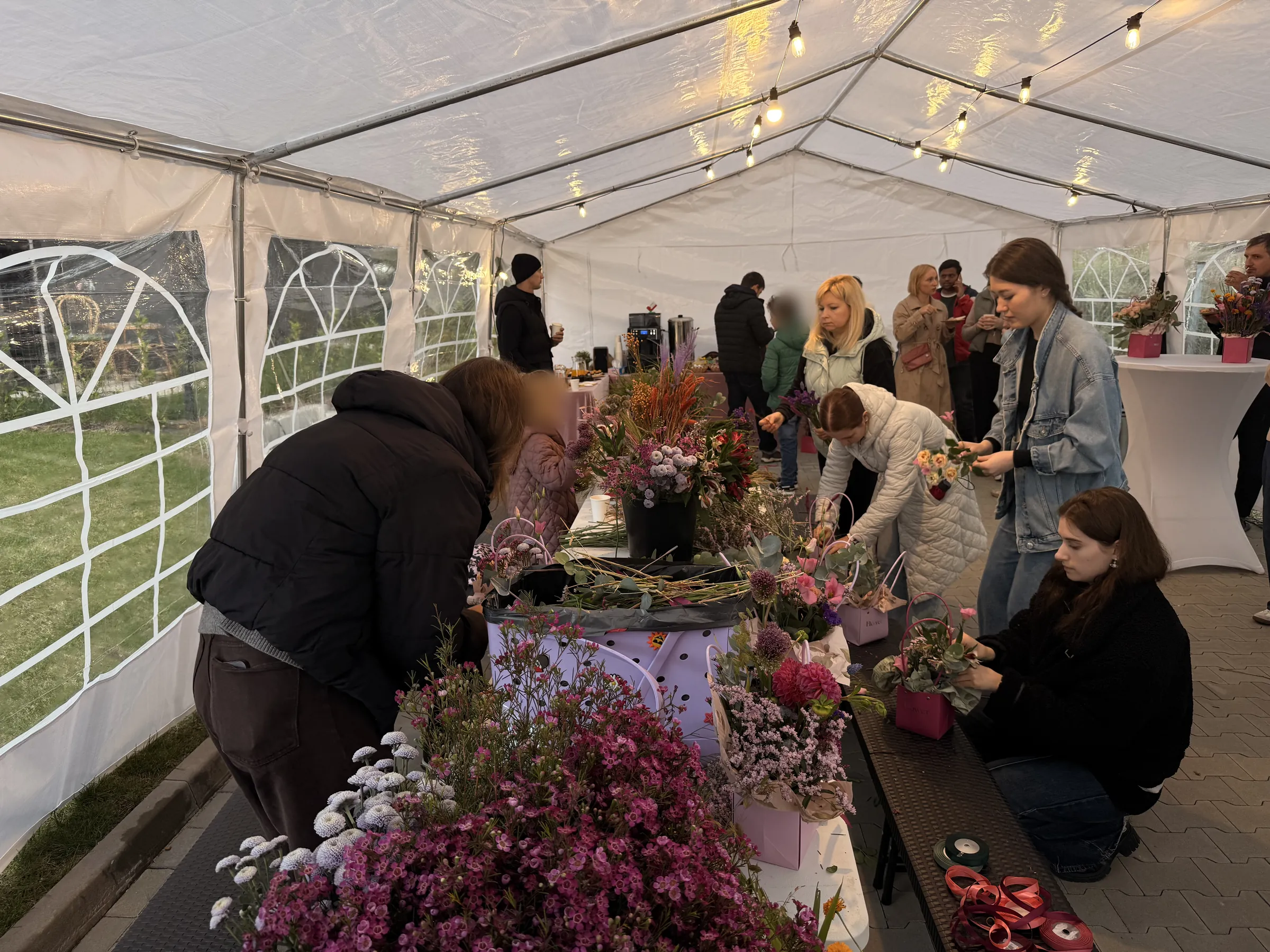 Mieszkańcy LifeSpot na warsztatach florystycznych w namiocie ogrodowym