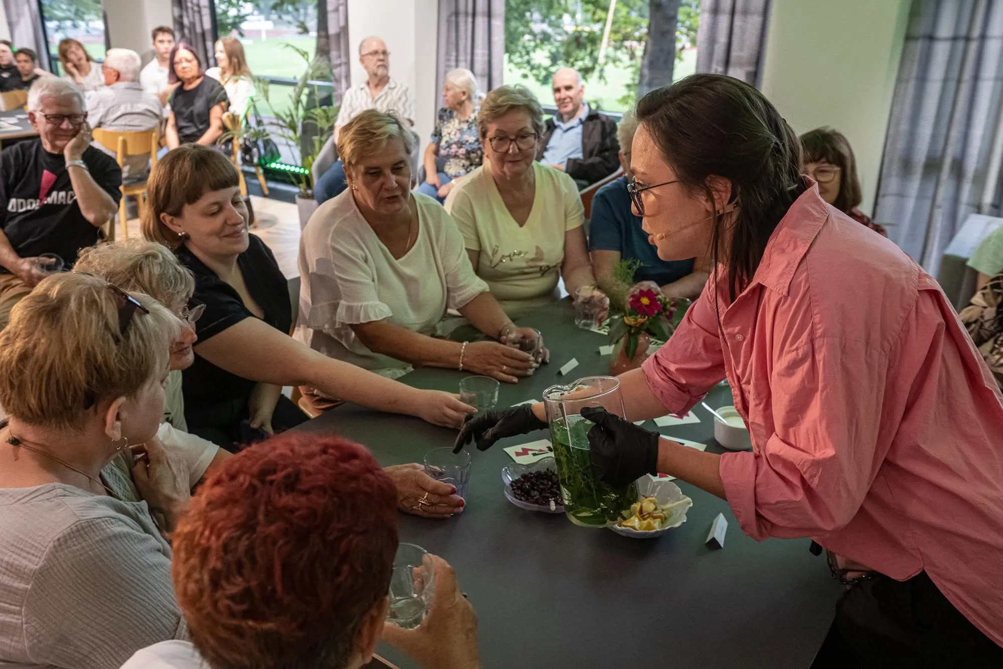 Zielarka nalewa napar do szklanek uczestników degustacji