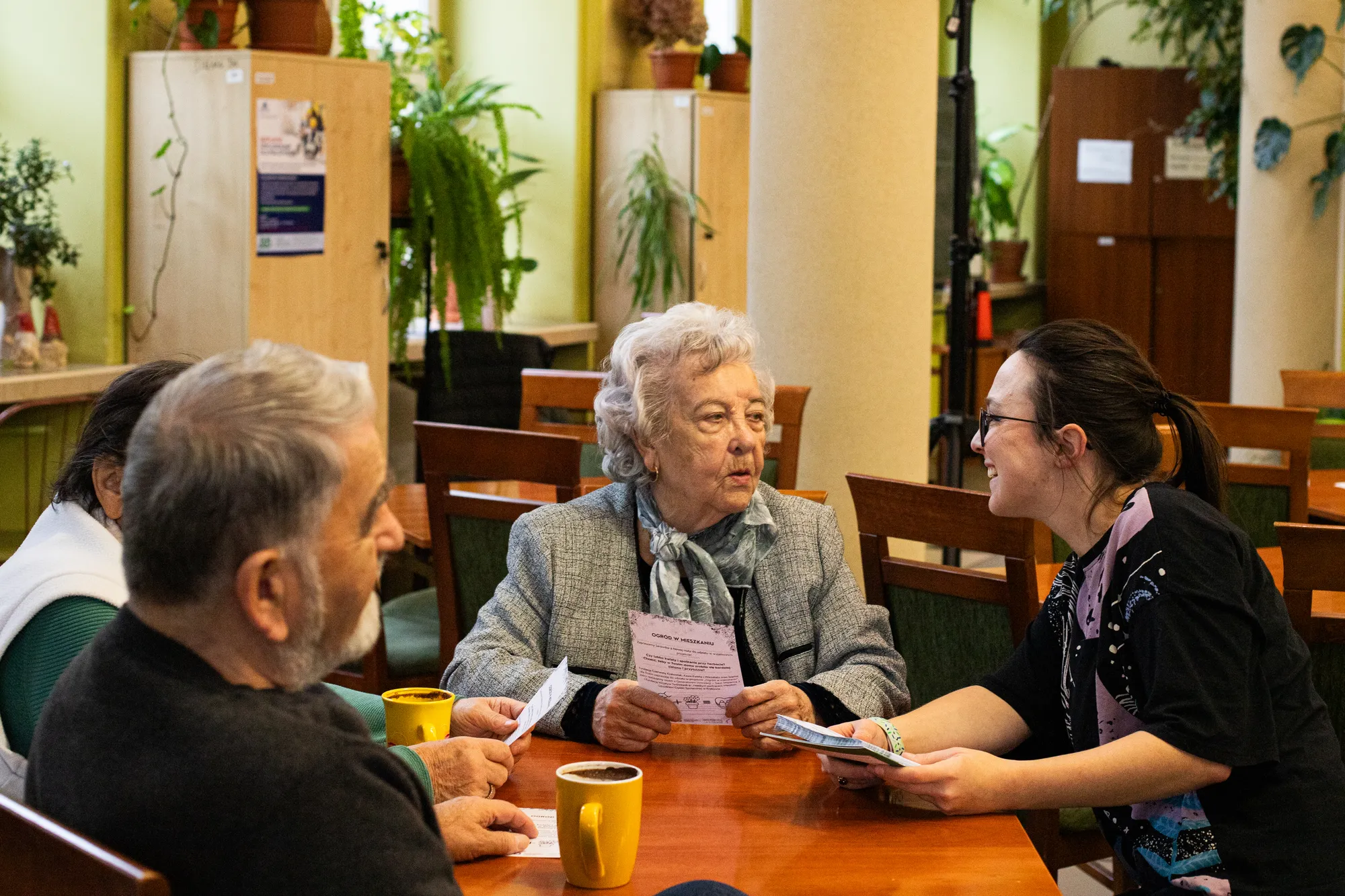 Beata Śpiewak-Siwulska, prezeska fundacji, rozmawia z seniorami przy kawie podczas warsztatów